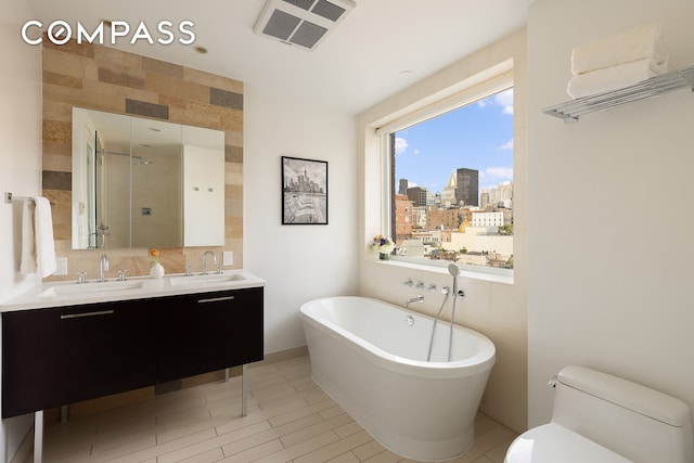 full bath featuring a soaking tub, visible vents, a shower stall, and a sink