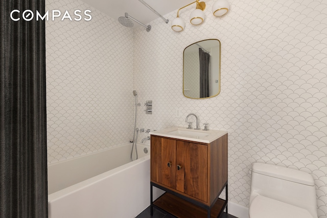 bathroom featuring vanity, wallpapered walls, toilet, and shower / washtub combination