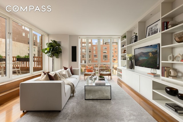 living area featuring built in features and wood finished floors