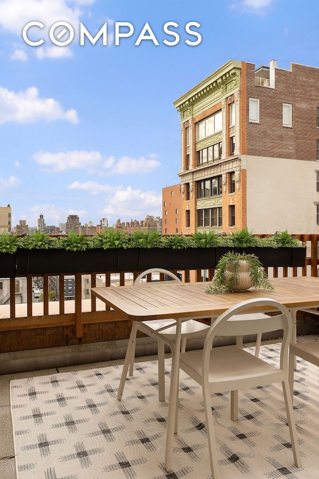 balcony featuring outdoor dining area and a city view