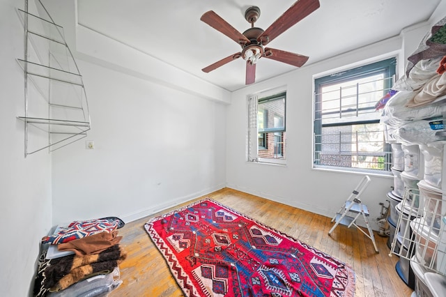 interior space featuring baseboards, a ceiling fan, and hardwood / wood-style floors