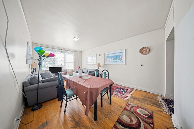dining area featuring baseboards and hardwood / wood-style flooring