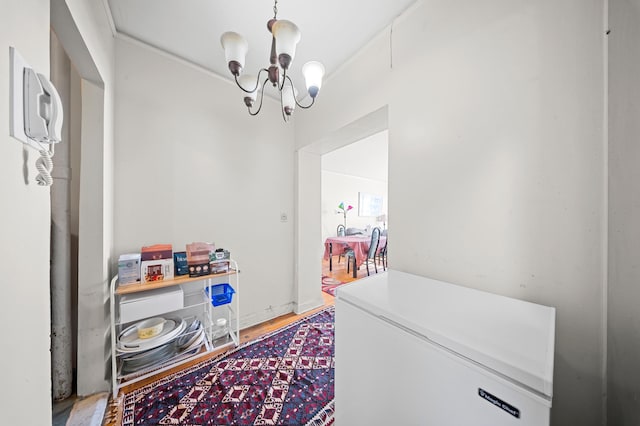 laundry area with wood finished floors and a notable chandelier