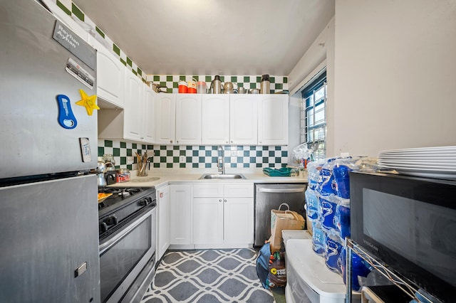 kitchen with light floors, a sink, white cabinetry, and stainless steel appliances
