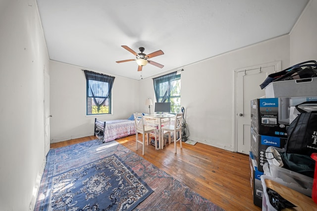 bedroom with baseboards, ceiling fan, and hardwood / wood-style flooring