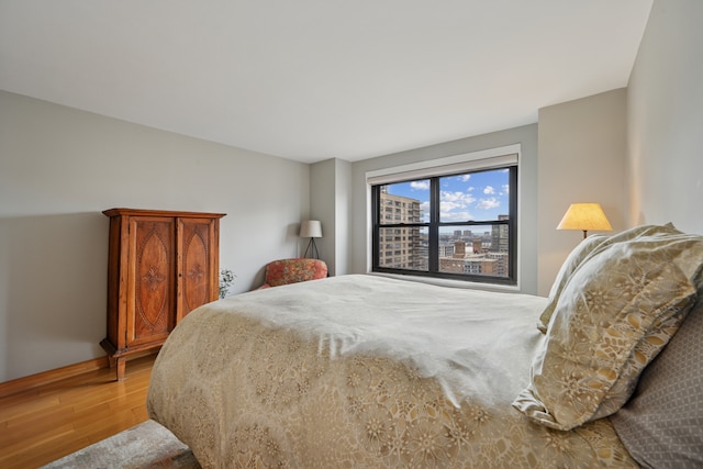 bedroom with baseboards and wood finished floors