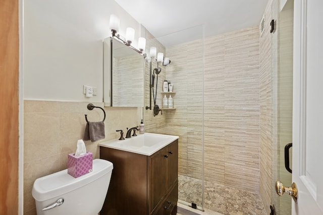 bathroom featuring vanity, tile walls, a shower stall, and toilet