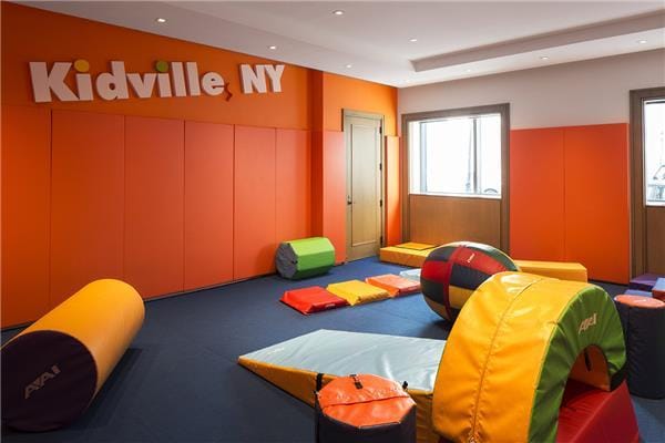 game room with carpet and a decorative wall