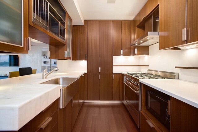 60 Riverside Blvd Unit 1502, New York City, NY 10069 - kitchen with high end stove, black microwave, exhaust hood, dark wood-style floors, and light countertops