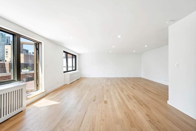 420 E 64th St Ephe, Ephe, New York City, NY 10065 - spare room with baseboards, recessed lighting, light wood-style flooring, and radiator heating unit