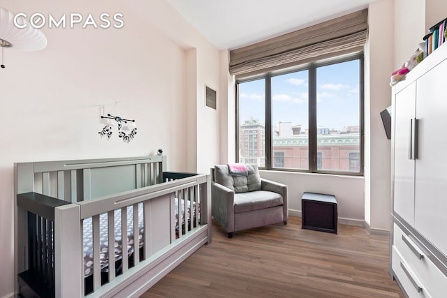 101 W 24th St Unit 5E, New York City, NY 10011 - bedroom with a crib, wood finished floors, and baseboards
