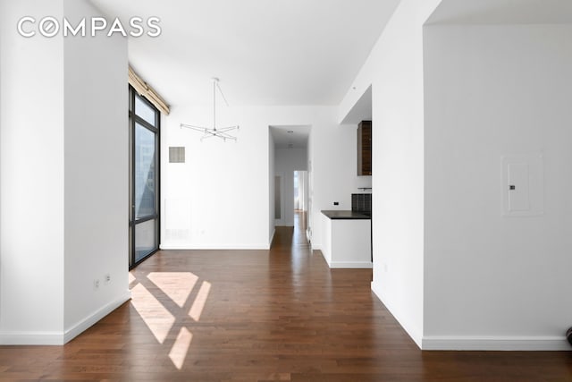 101 W 24th St Unit 5E, New York City, NY 10011 - unfurnished room featuring a chandelier, dark wood finished floors, and baseboards