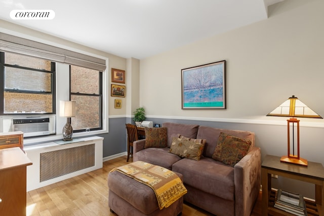 334 W 87th St Unit 6A, New York City, NY 10024 - living area with radiator, wood finished floors, cooling unit, and baseboards