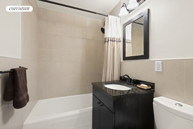 bathroom featuring toilet, tile walls, shower / bath combination with curtain, and vanity
