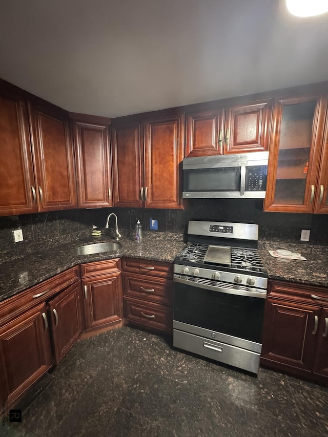 1264 E 73rd St, New York City, NY 11234 - kitchen with appliances with stainless steel finishes, a sink, tasteful backsplash, and dark stone countertops