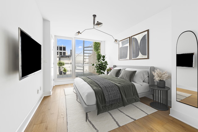 bedroom with light wood-type flooring and baseboards