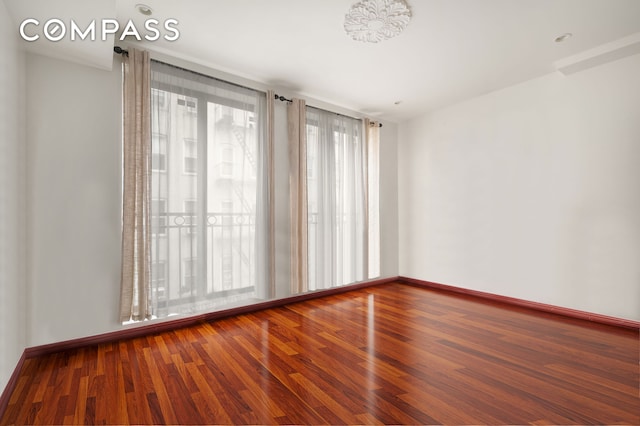 unfurnished room featuring wood finished floors and baseboards