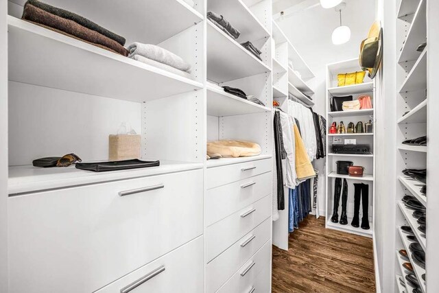 walk in closet with dark wood-style flooring