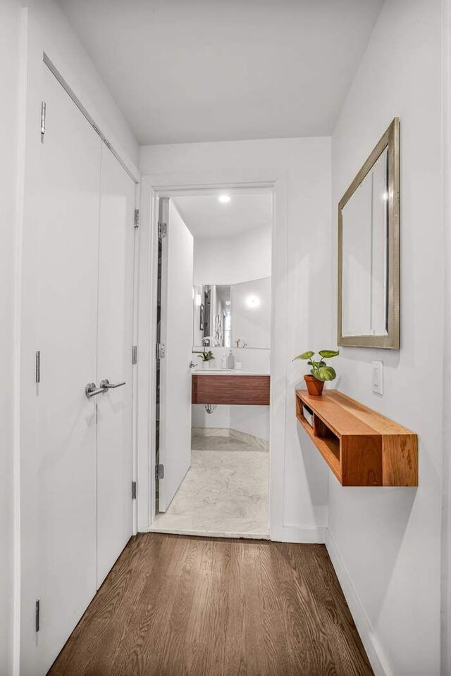 hallway with baseboards and wood finished floors