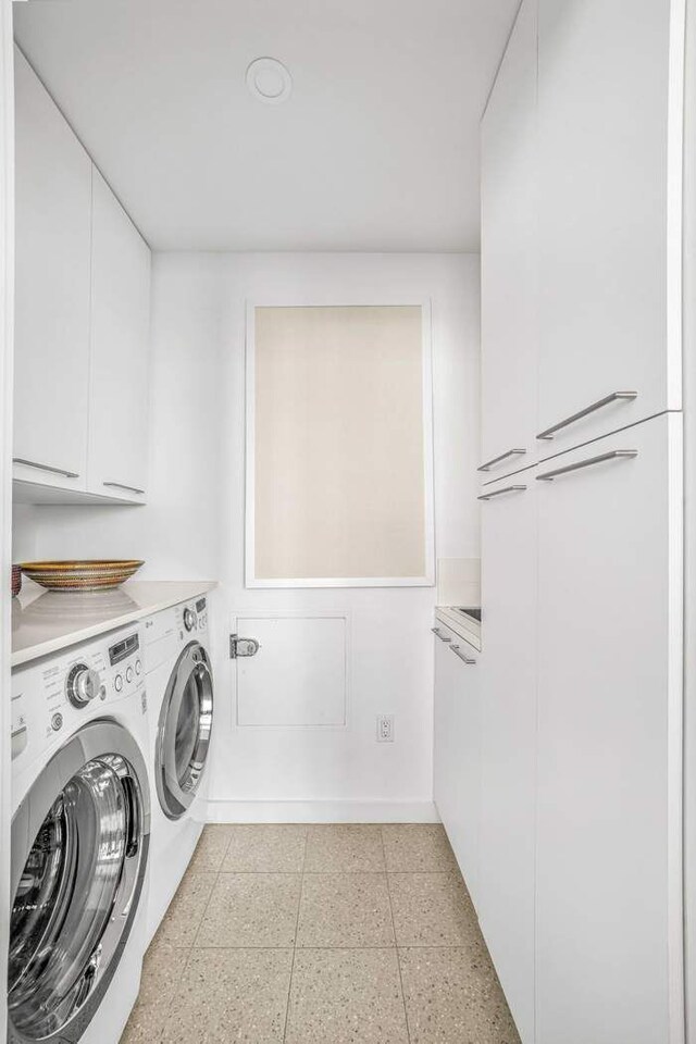 laundry area featuring independent washer and dryer and cabinet space