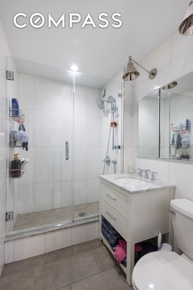 full bathroom featuring tile patterned flooring, vanity, toilet, and a shower stall