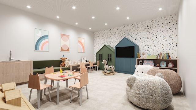 game room featuring an accent wall, wallpapered walls, recessed lighting, light colored carpet, and a sink
