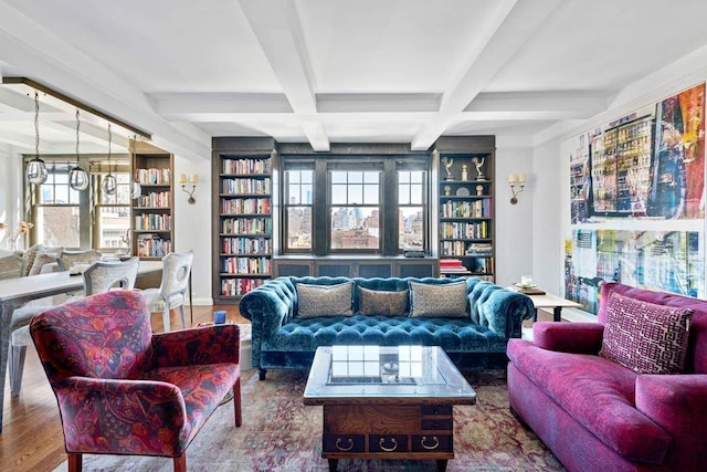 living area featuring beamed ceiling, built in features, wood finished floors, and coffered ceiling