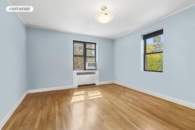 unfurnished room with visible vents, ornamental molding, baseboards, and wood finished floors