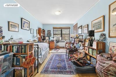 sitting room with visible vents, ornamental molding, and wood finished floors
