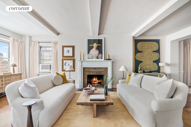 living room featuring a fireplace, beam ceiling, and visible vents