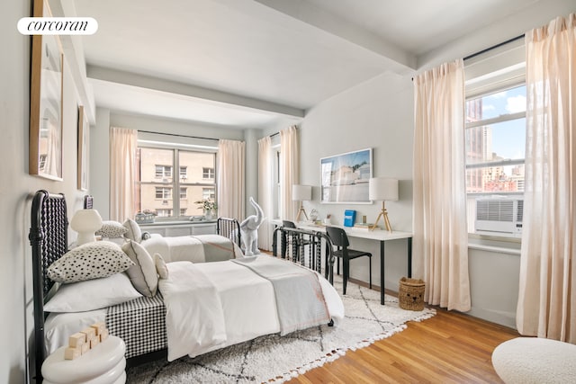 400 E 52nd St Unit 12Ff, New York City, NY 10022 - bedroom featuring multiple windows, wood finished floors, beamed ceiling, cooling unit, and an office area