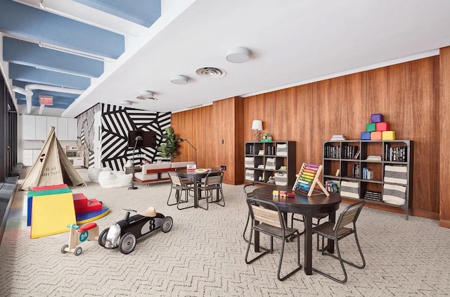 game room with visible vents, carpet flooring, and wood walls