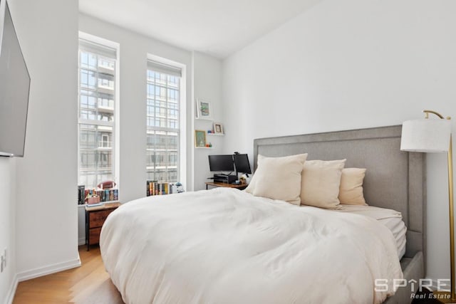 bedroom featuring light wood-style floors and baseboards