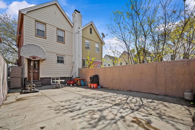 1462 E 65th St, New York City, NY 11234 - back of property with a chimney, a patio, and a gate
