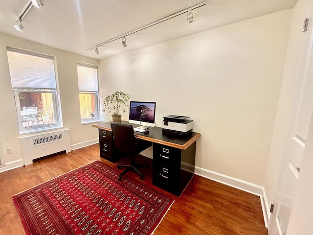 office with track lighting, baseboards, wood finished floors, and radiator