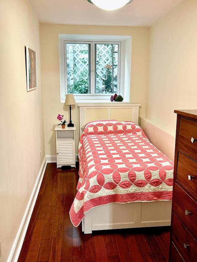 bedroom featuring baseboards and dark wood-style flooring