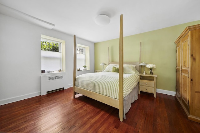 bedroom featuring baseboards, radiator heating unit, and hardwood / wood-style floors
