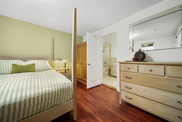 bedroom with connected bathroom and dark wood-type flooring