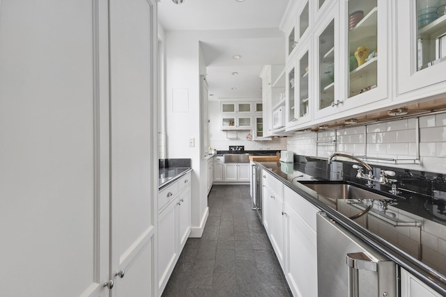 1 E End Ave Unit 8A, New York City, NY 10075 - kitchen featuring a sink, decorative backsplash, white cabinetry, dark countertops, and glass insert cabinets