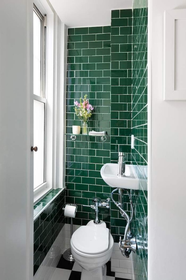 bathroom featuring a sink, tile walls, tile patterned floors, and toilet