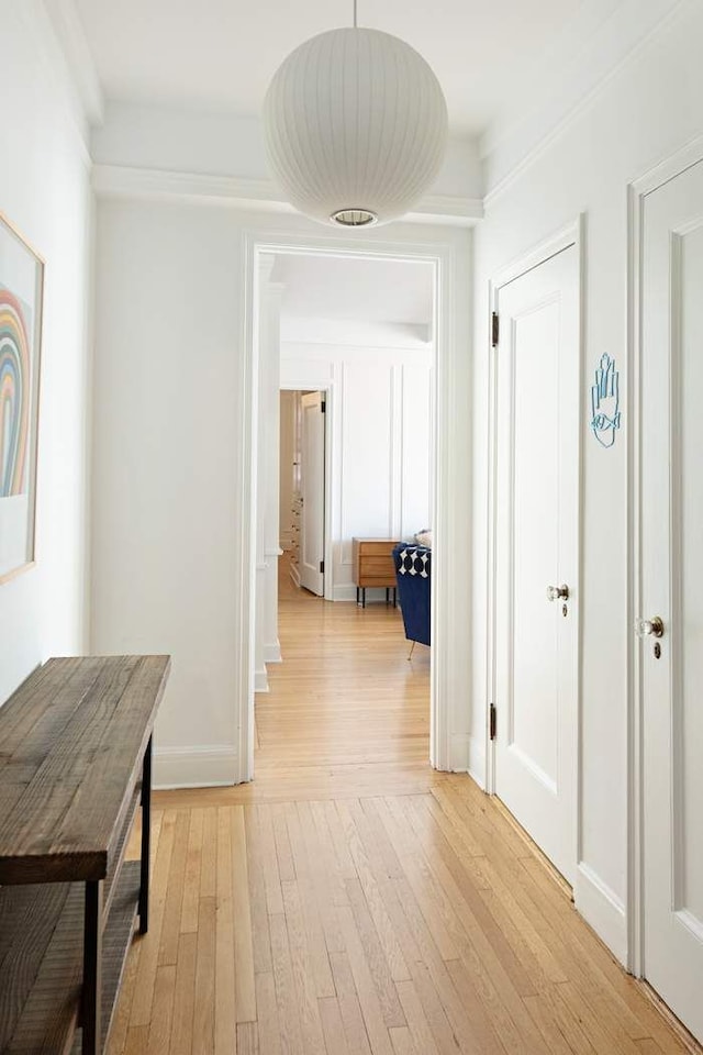 hall featuring light wood-style floors and baseboards