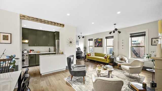 living area with recessed lighting and light wood finished floors