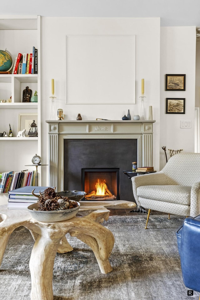 sitting room with a lit fireplace