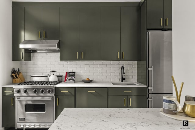 kitchen featuring appliances with stainless steel finishes, light stone counters, a sink, decorative backsplash, and under cabinet range hood