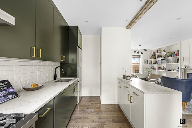 kitchen with range, tasteful backsplash, a sink, a peninsula, and dark wood-type flooring