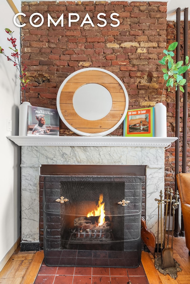 interior details featuring a high end fireplace, baseboards, and wood finished floors