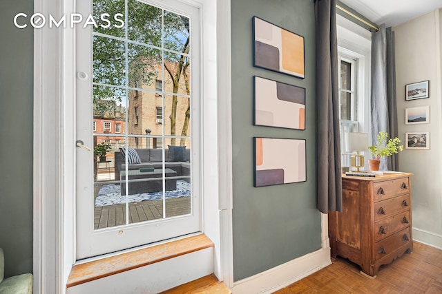 doorway to outside featuring baseboards