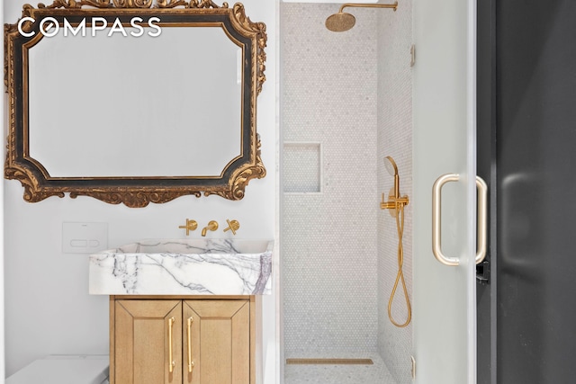 full bathroom featuring vanity and tiled shower