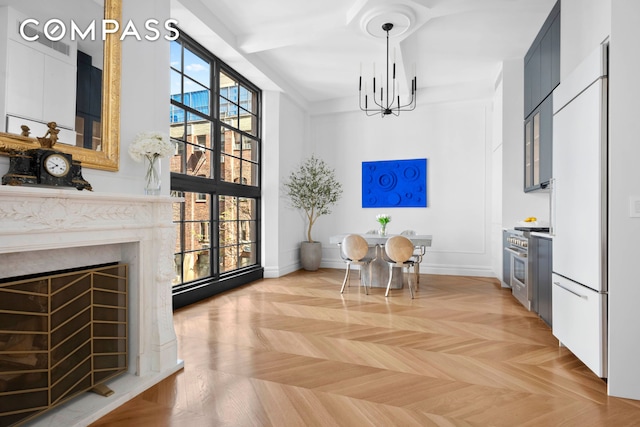 dining area featuring baseboards, a notable chandelier, and a fireplace