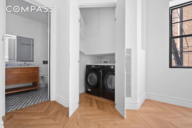 washroom featuring washer and dryer, a heating unit, baseboards, and laundry area